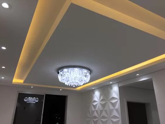 sala de jantar com sanca inevrtida com ilha e lustre cristal