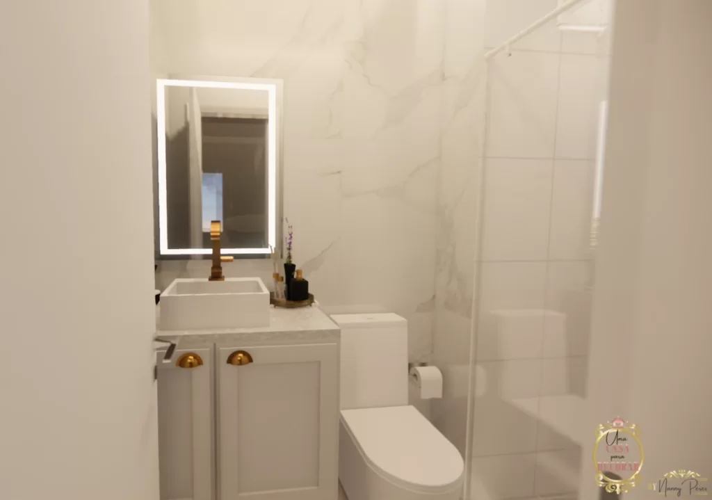 Banheiro com revestimento marmorizado, com móvel provençal clásico e espelho de led